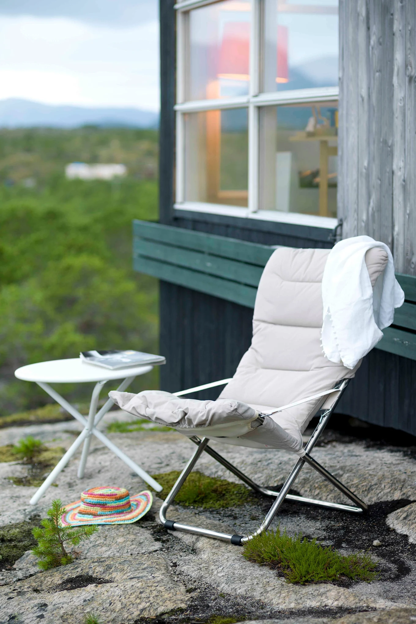 La tumbona Fiesta Soft de Fiam se encuentra en una terraza en medio del bosque. Su fácil plegado la convierte en una de las tendencias de mobiliario de jardín de este año.