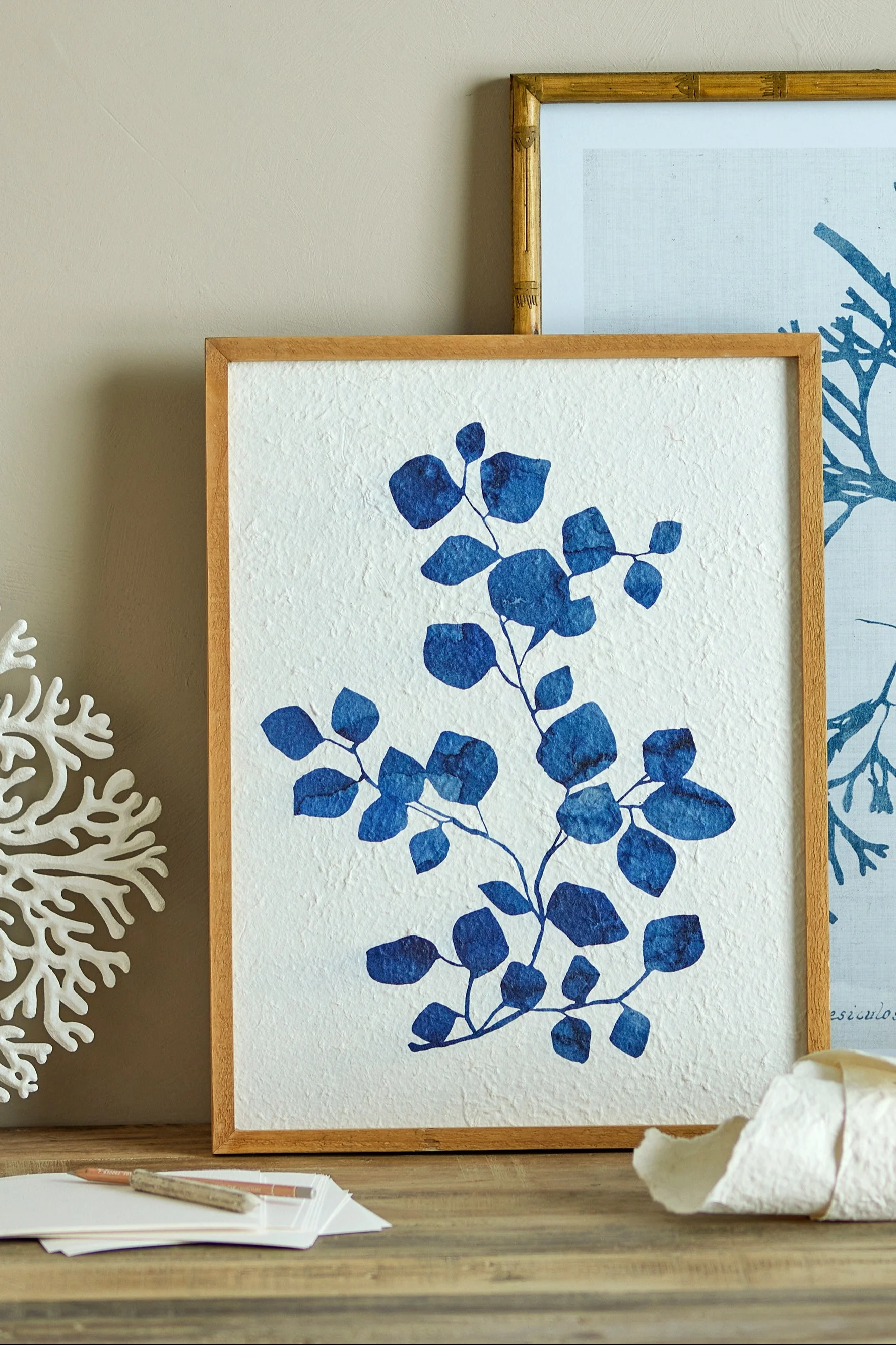 El cuadro Gunnvor azul en un marco de madera de Bloomingville se alza sobre una cómoda y es la decoración boho perfecta.