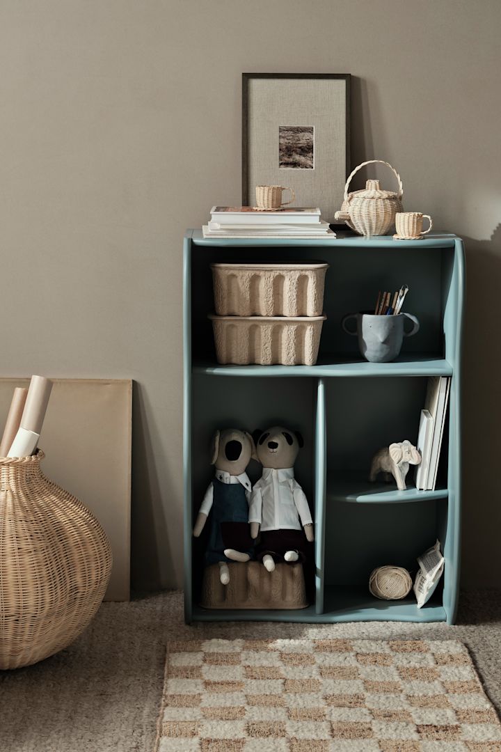 Una librería pequeña con capacidad para mucho, la librería storm Slope en color azul de Ferm Living tiene cuatro compartimentos de diferentes tamaños, lo que la convierte en lo último tanto para libros como para cajas y juguetes.