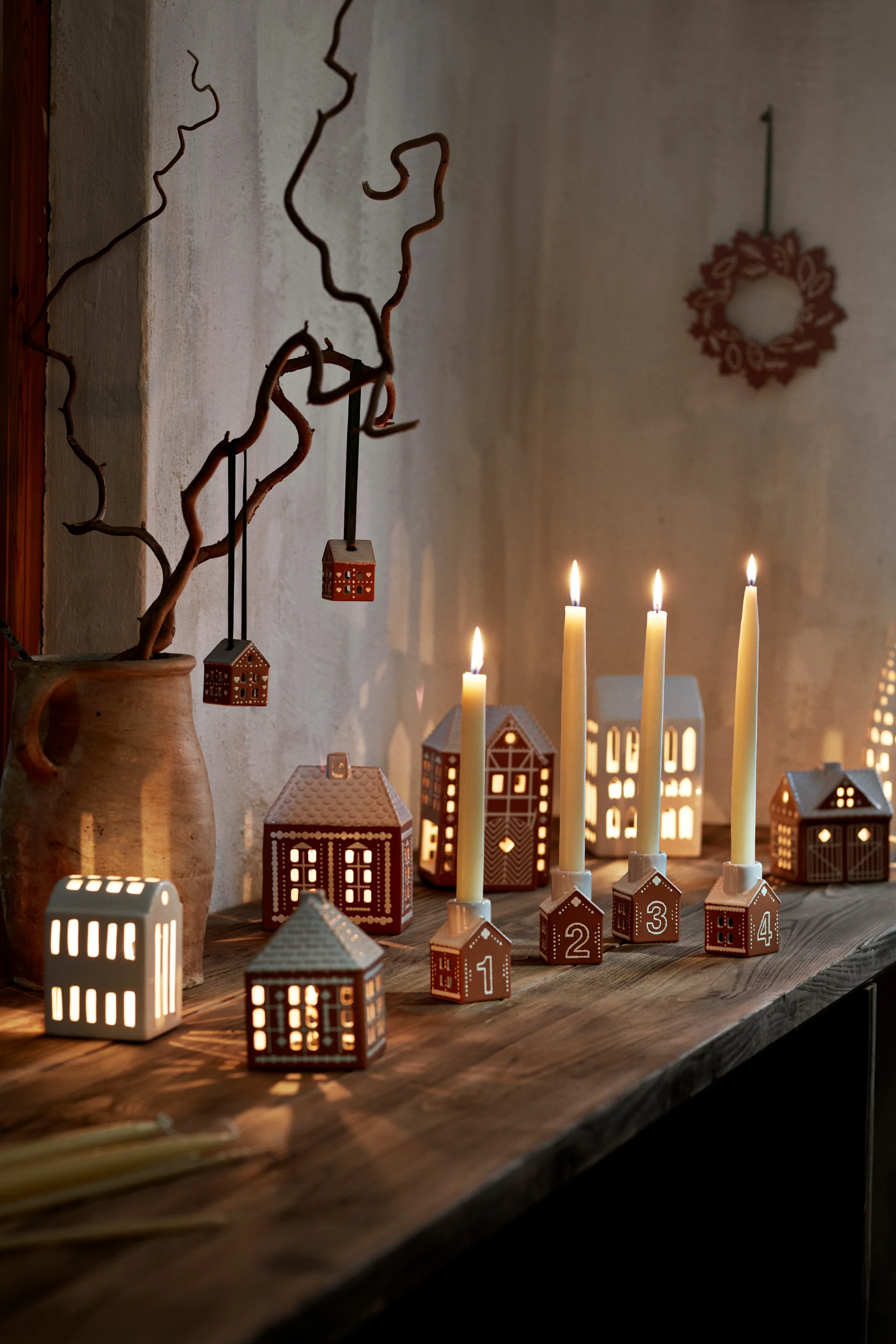 Un pueblo navideño hecho con las casas luminosas de Kähler es la decoración navideña escandinava perfecta.