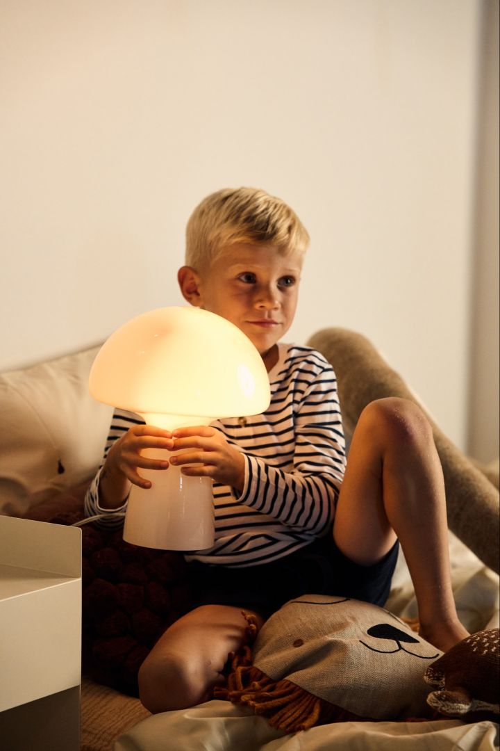 Elige la bombilla adecuada: un niño sostiene una lámpara incandescente con forma de seta.