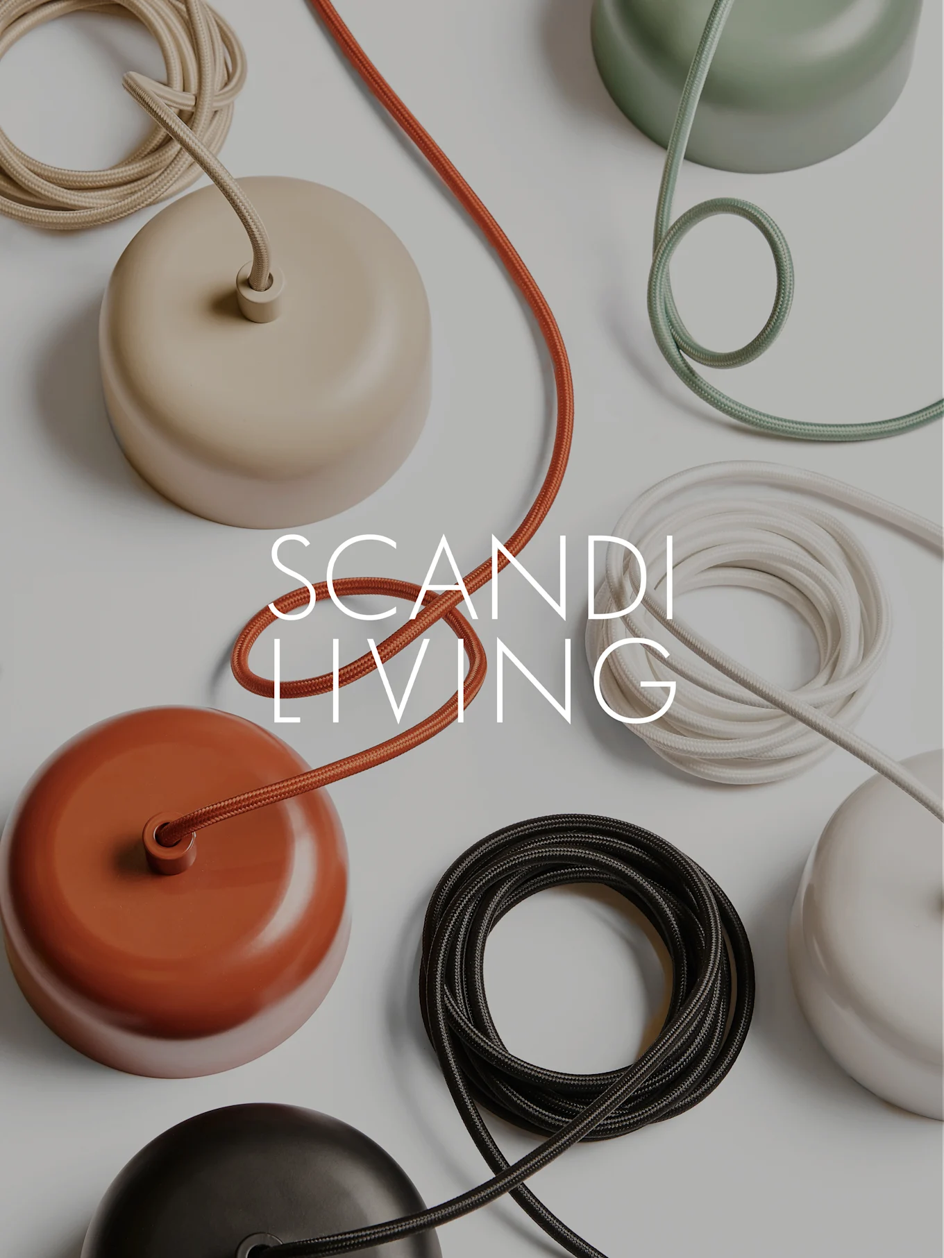 Texto SCANDI LIVING sobre una disposición plana de coloridas tapas de rosetones de techo abovedadas y cables de tela enrollados.
