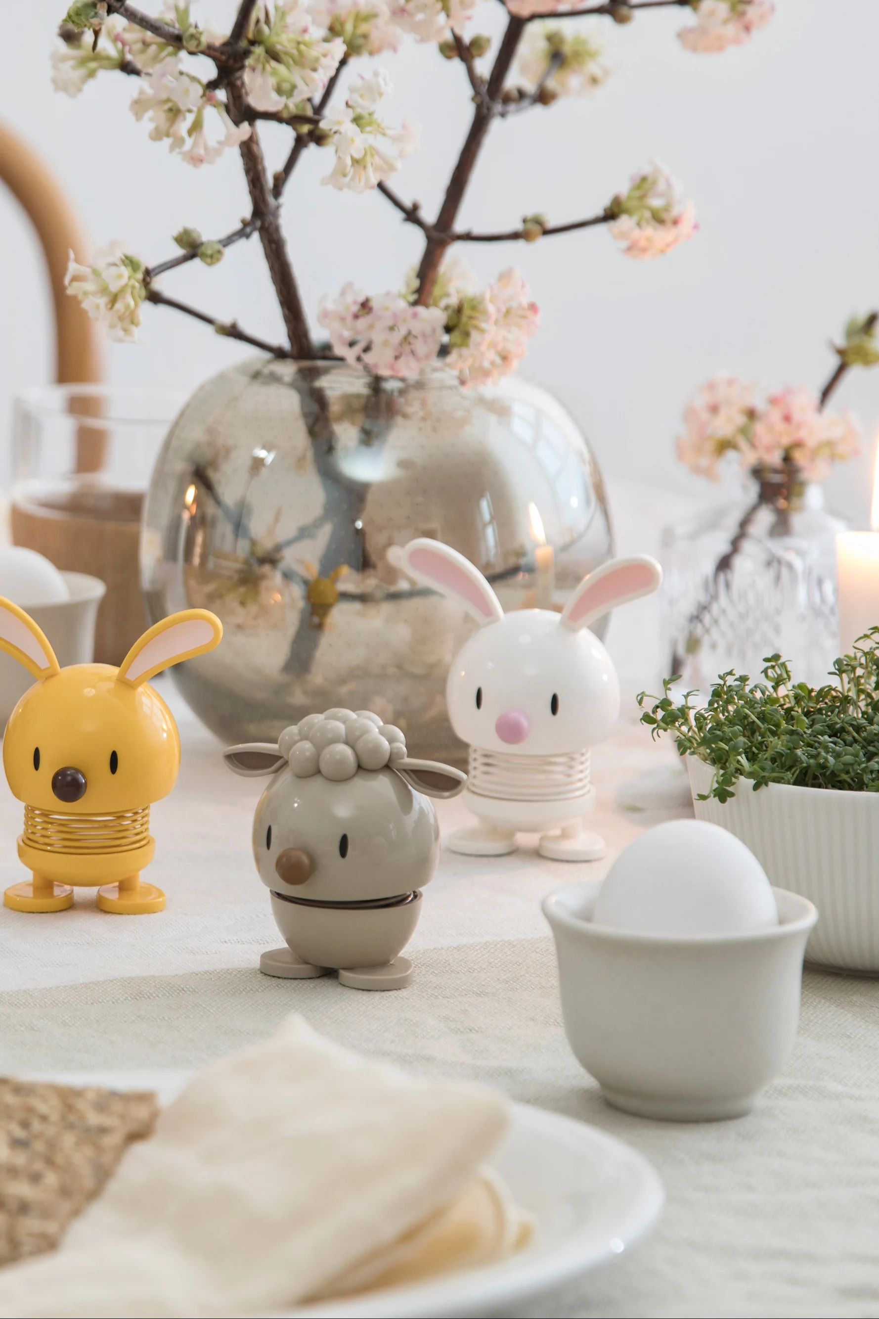 Las distintas figuras de Hoptimist son el regalo perfecto para el Día de San Valentín para quienes disfrutan coleccionando. Aquí se muestran las figuras Bunny y Lamb sobre una mesa puesta.
