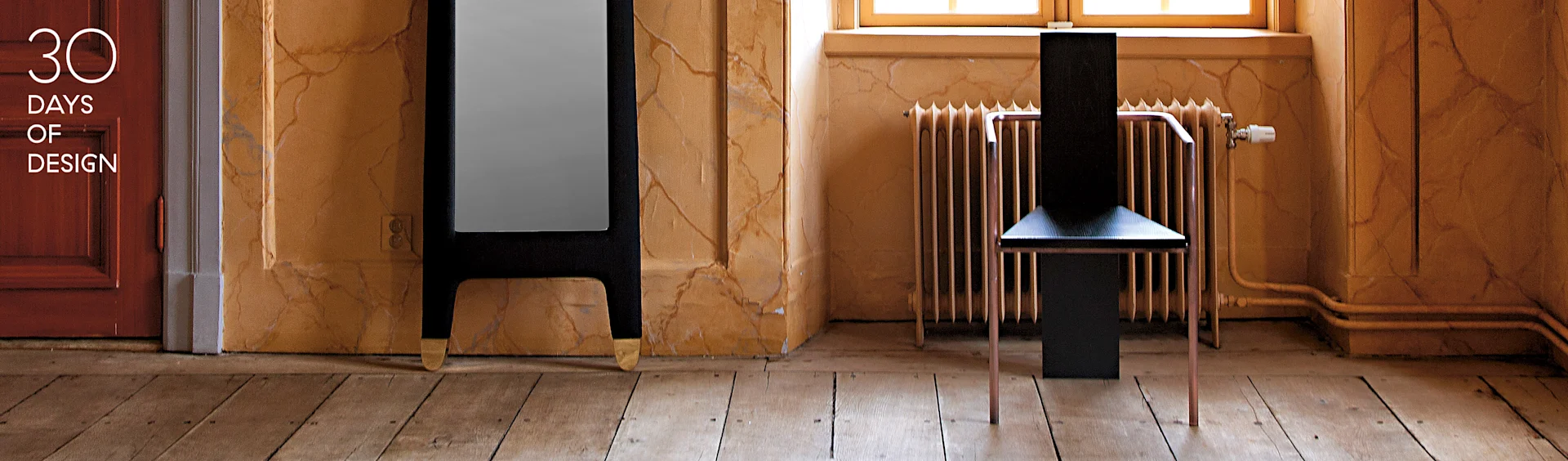 Silla negra moderna con patas de cobre, espejo alto oscuro con pies dorados, en una habitación con paredes texturizadas. Texto: 30 DAYS OF DESIGN.