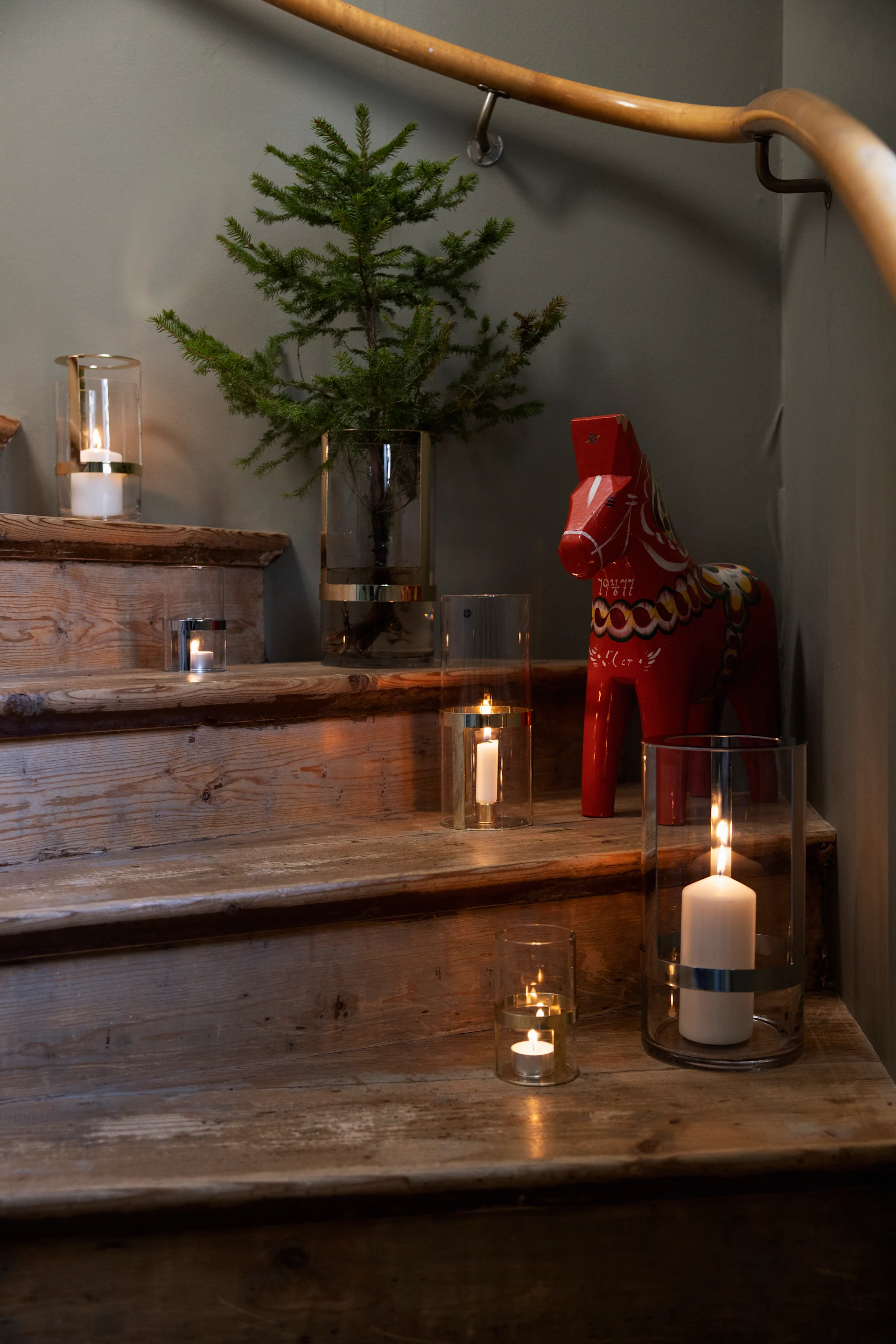 Decore también la escalera para entrar en ambiente navideño. Coloque el jarrón Hold de Sagaform en diferentes tamaños en varios escalones y llénelos con velas y ramas de abeto. Un Dalahäst completa la decoración.