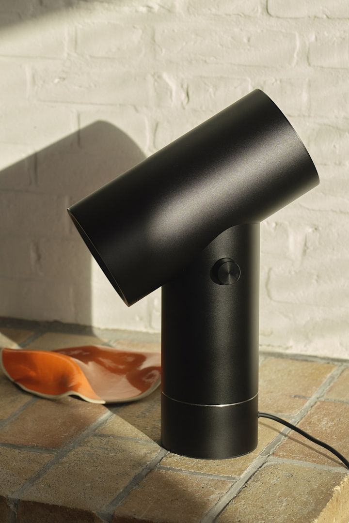 La lámpara de mesa Beam negra de Muuto en un entorno de azulejos.