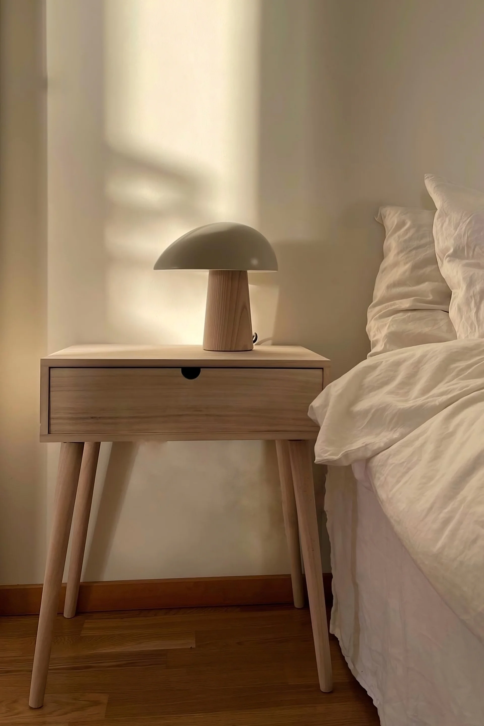 Los muebles sencillos son perfectos para el feng shui. @homebyhanna tiene una sencilla mesita de noche de madera junto a su cama con la lámpara de mesa Night Owl de Fritz Hansen encima.