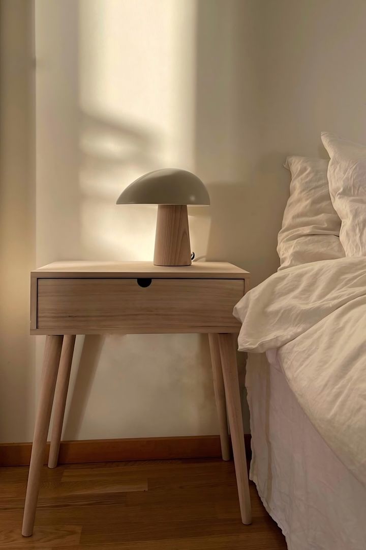 Los muebles sencillos son perfectos para el feng shui. @homebyhanna tiene una sencilla mesita de noche de madera junto a su cama con la lámpara de mesa Night Owl de Fritz Hansen encima.