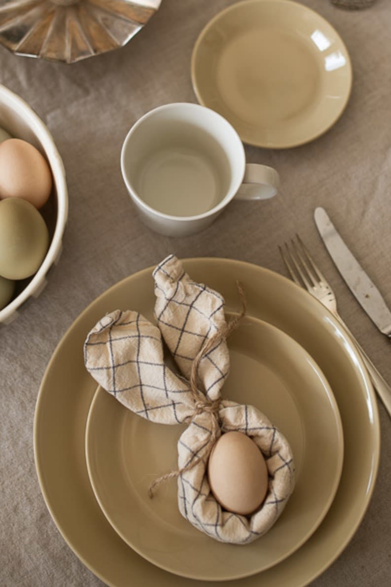Dobla la servilleta en forma de orejas de conejo para una encantadora idea de decoración de mesa de Pascua.