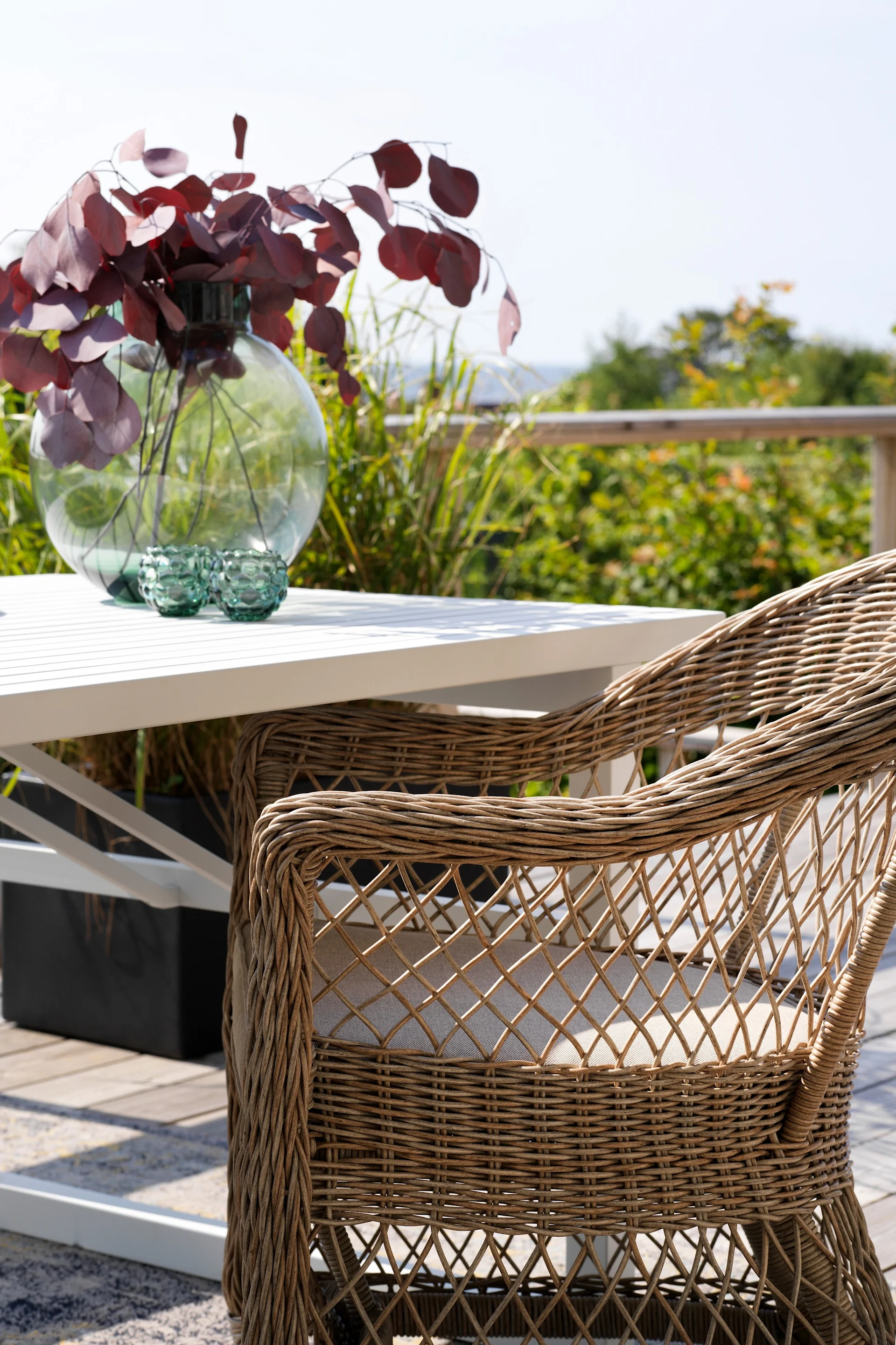 El sillón Kamomill de Brafab frente a la mesa de una terraza.