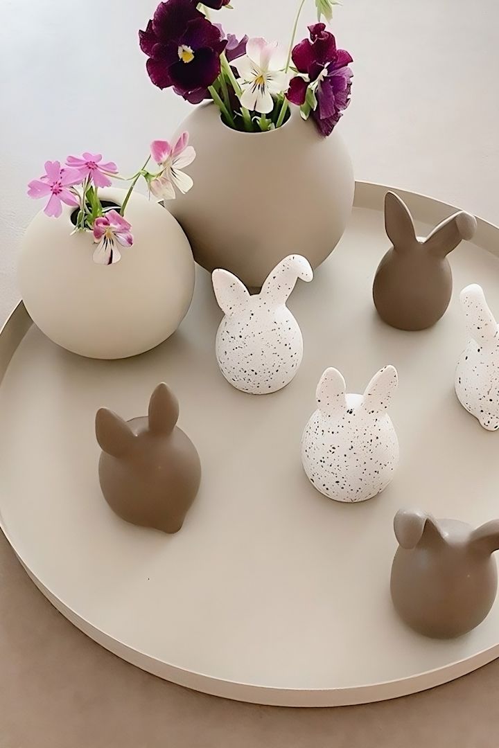 Los conejitos de Pascua trillizos en dos colores de DBKD están sobre una bandeja, junto a dos jarrones redondos de Cooee Design en el hogar de @sachi_roooom.