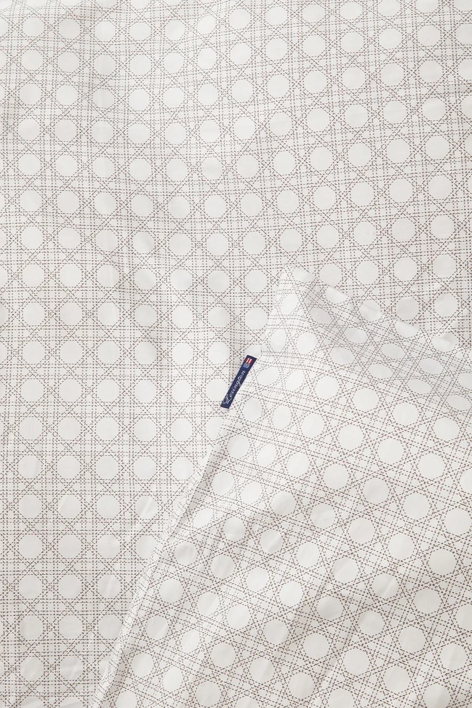Tejido blanco con patrón marrón claro y etiqueta azul de Lexington.