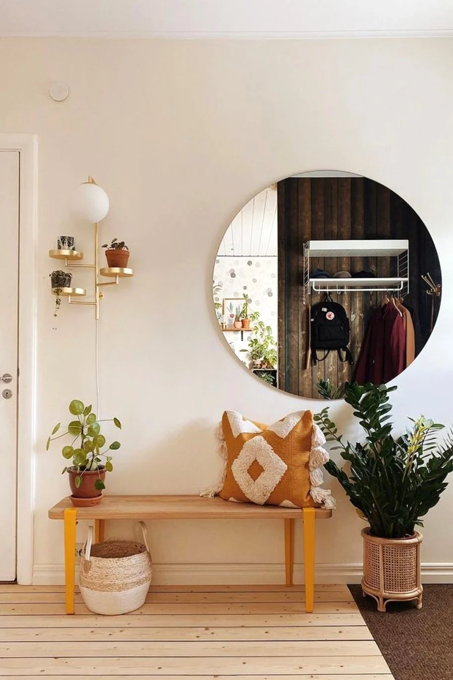 Decora tu recibidor en estilo boho con un banco, cojines estampados, plantas y el aplique Astoria de Globen Lighting.