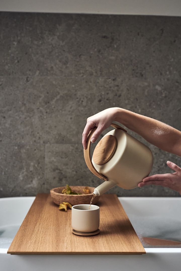 Decora tu cuarto de baño para momentos de relax con la tetera y la taza Theo de Stelton y el cuenco de corcho Formgatan lleno de fruta para crear la sensación de un spa en casa.