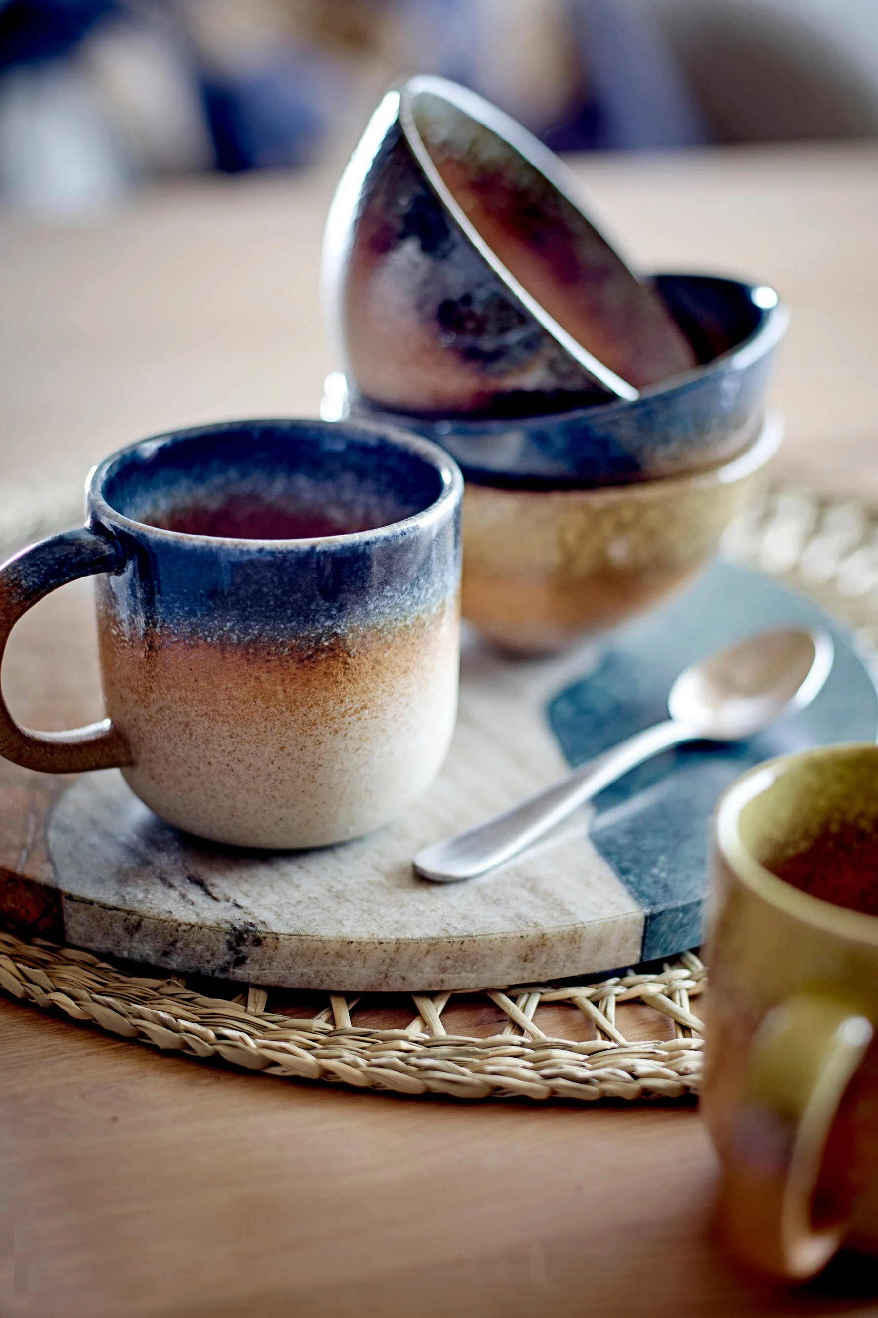 La taza Aura de Bllomingville, en la imagen sobre una mesa, es la decoración boho perfecta gracias a su combinación de colores.