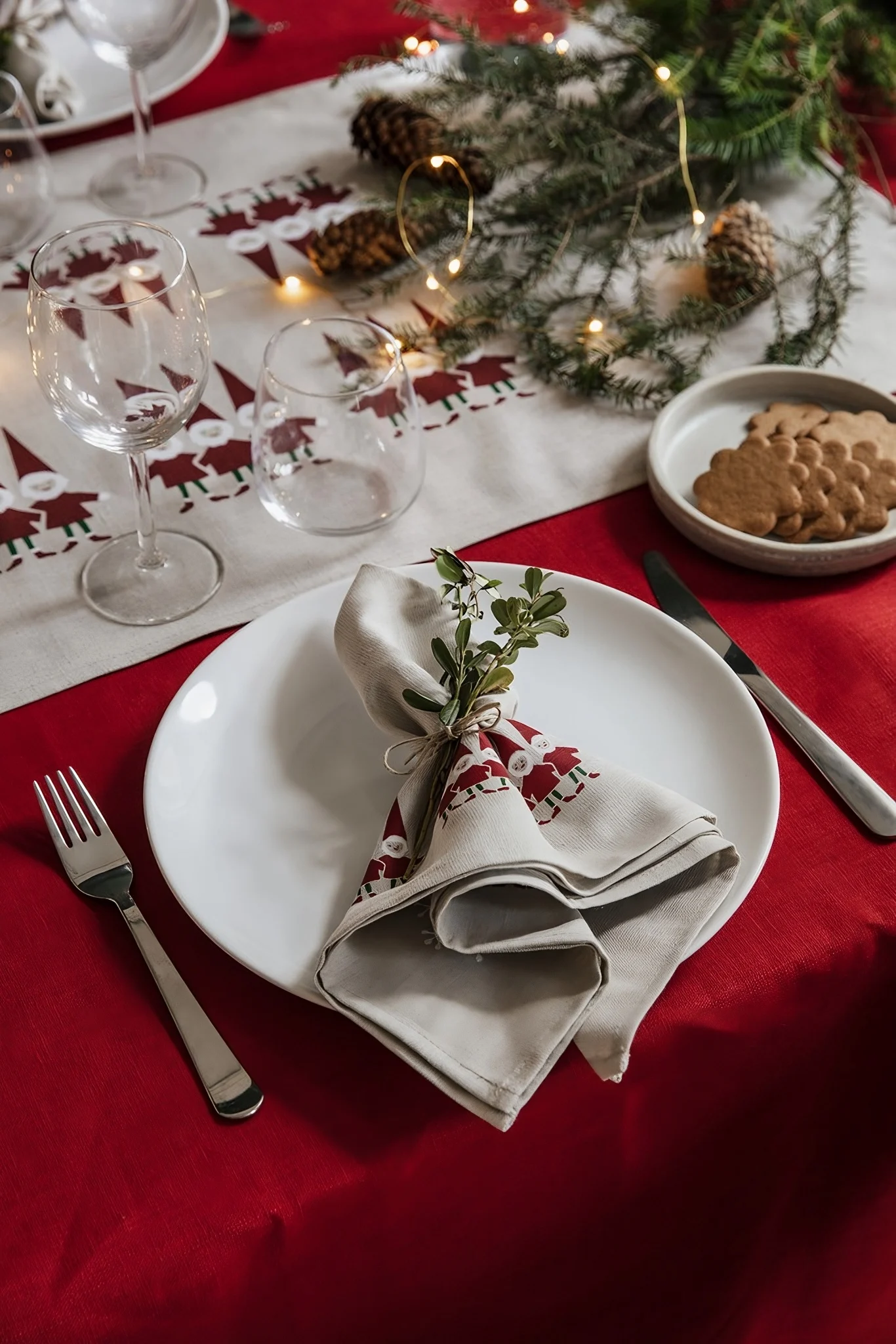 Una mesa decorada para Navidad es indispensable en Suecia. Aquí está vestida de rojo, decorada con ramas de abeto y con un camino de mesa con un Tomte.