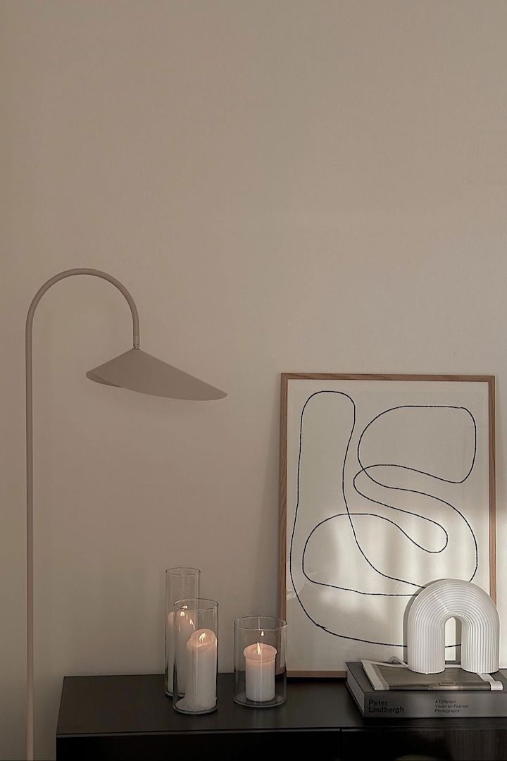 La cómoda de @helenas.hem, decorada con velas, un cuadro, la lámpara de mesa Vuelta y la lámpara de pie Arum a su lado.