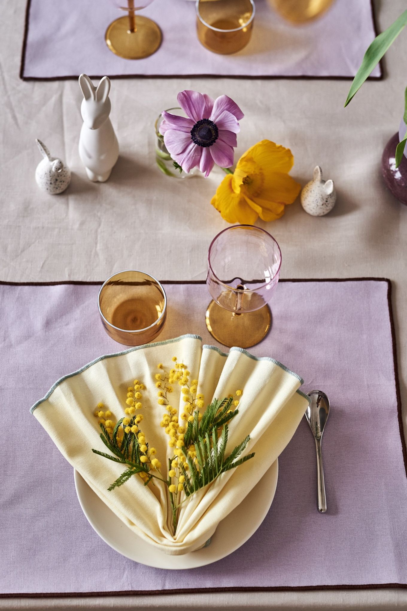 Tus ideas para la mesa de Pascua siempre deberían incluir un doblado de servilleta como el que ves aquí, en tonos amarillos.