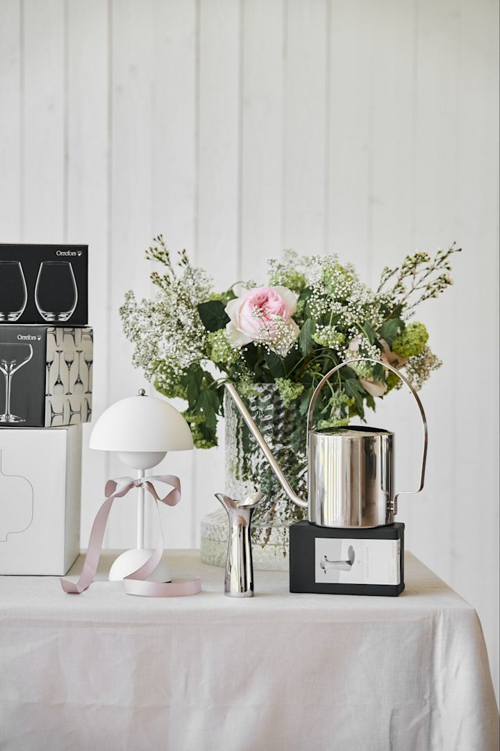 Incluye estas ideas de boda únicas en tu gran día. Aquí se ve una regadera de acero inoxidable de Stelton y un jarrón de Georg Jensen sobre una mesa de regalos de boda.
