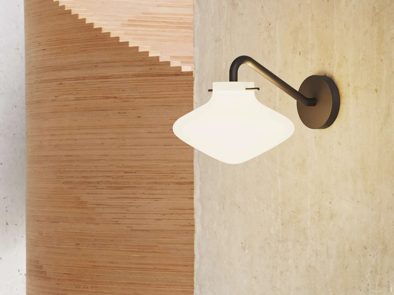 Un aplique de pared con pantalla de cristal blanco y redondeado en una pared de hormigón, junto a una estructura de madera curvada.