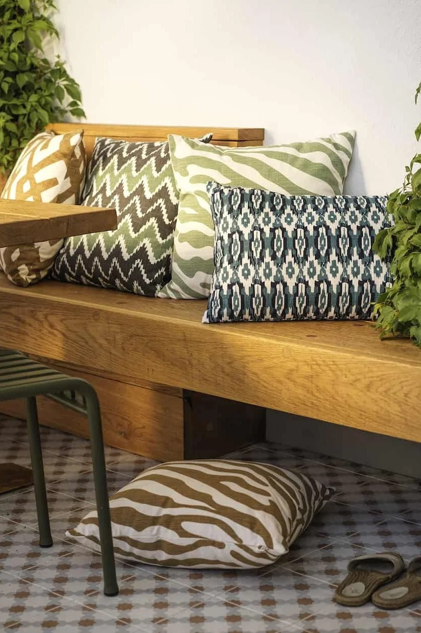 Una gran variedad de colores y estampados crean un ambiente bohemio. Aquí puede ver varios cojines de Chhatwal & Jonsson en un balcón de estilo bohemio.