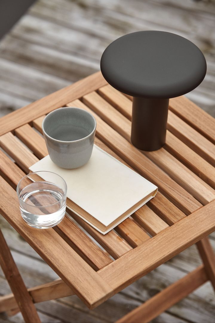 La lámpara portátil Takku en negro de Artemide es una elegante lámpara recargable que crea un suave y acogedor resplandor en el patio, ya sea en la pequeña mesa de centro o en la gran mesa de comedor.