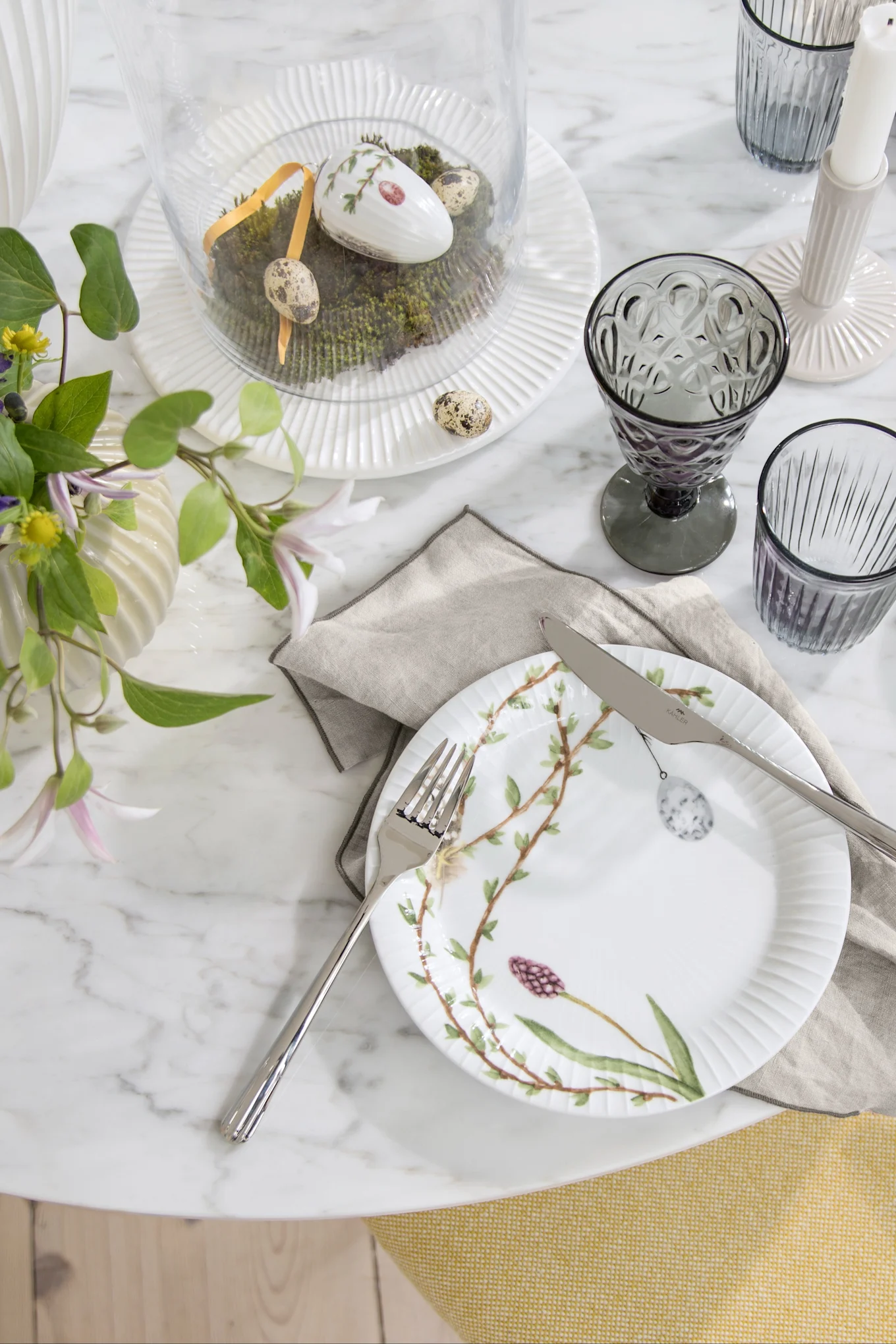 Decoración de Pascua para la mesa: el plato de Pascua Hammershøi de Kähler, decorado con motivos de Pascua, se encuentra en una mesa puesta para la celebración.